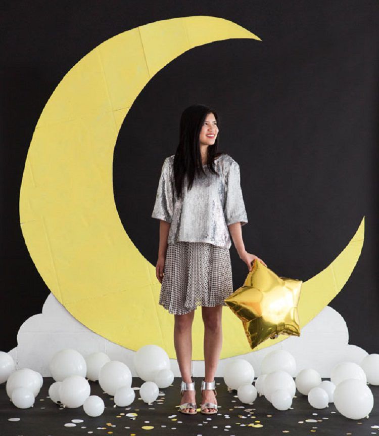 A Moon Photo Backdrop with a woman in a silver dress in front
